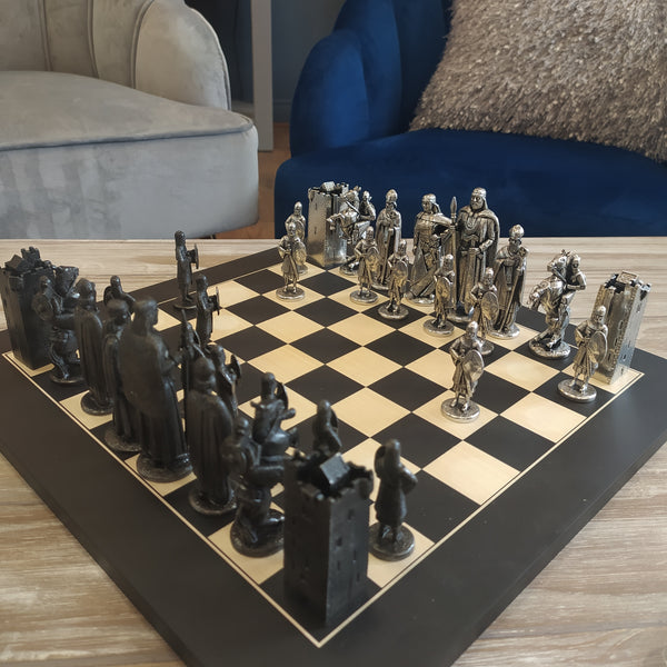 Silver coloured Pewter metal chess set on wooden board