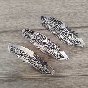 Celtic Pocket Tool Collection  has 3 styles to choose from, Dublin, Ireland and Plain. This photo shows the 3 options on a grey wood surface. Each piece is made of stainless steel and embellished with Pewter metal