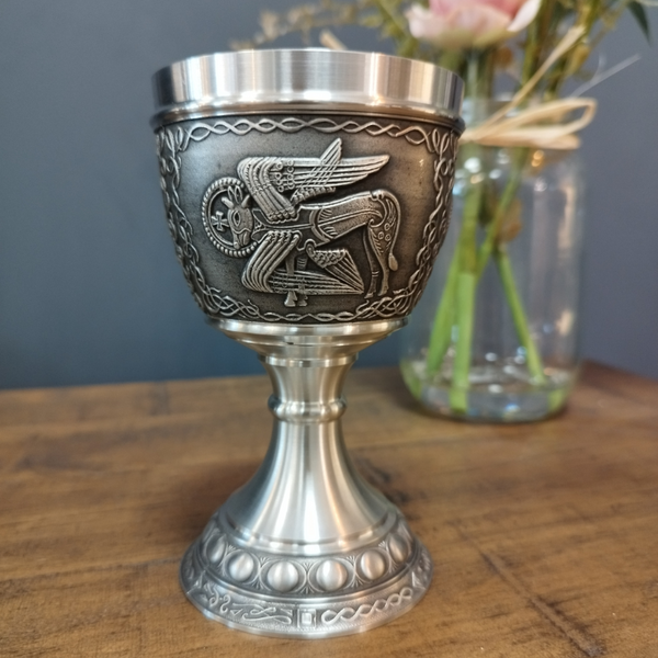 BOOK OF KELLS GOBLET LUKE THE OX. AS THE MONKS SET ABOUT CREATING THE BOOK OF KELLS THEY PICKED LIVING CREATURES TO REPRESENT THE EVANGELISTS. LUKE WAS REPRESENTED AS A WINGED OX. THE GOBLET STANDS AT6" TALL AND HOLDS 8 FLUID OZS. PEWTER/ SILVER FINISH