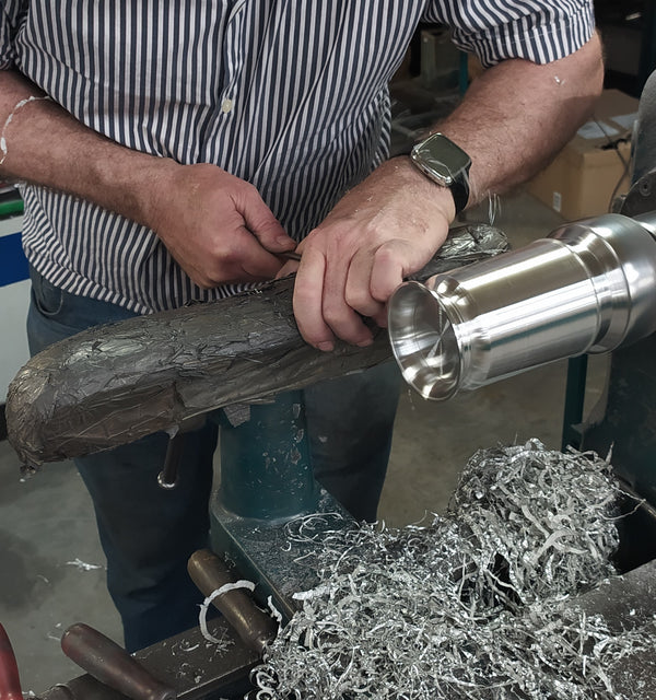 A skilled turner turning the outside of a pewter tankard