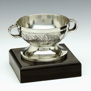 Small Chalice made of pewter and embellished with celtic knot work. Sitting ona  a dark presentation block