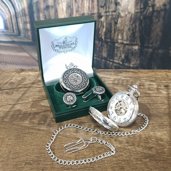 Boxed Mullingar Pewter Mechanical pocket watch which is decorated with a shamrock. It is a set with Cufflinks in shamrock also. In Front of it in lies the pocket watch open showing the inside.