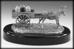 OFF TO THE CREAMERY SCULPTURE. IN IRELAND IT WAS WHAT FARMERS FROM ALL AROUND IRELAND DID. BRING MILK TO THE CREAMERY. THIS 8" LONG SCULPTOR IS VERY MUCH REPRESENTATIVE OF IRELAND OF THE PAST.