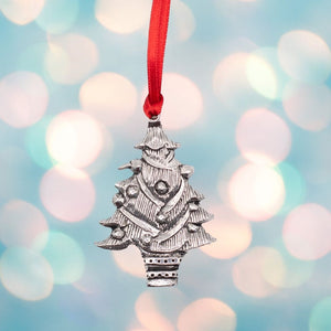 A silver coloured pewter Christmas Tree decoration which is hung on a red ribbon