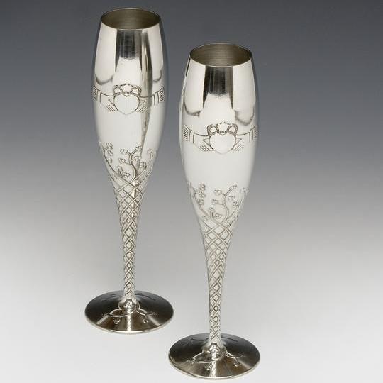 A pair of champange flutes with claddagh and ornate vine pattern made from Mullingar Pewter