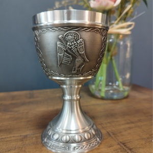 BOOK OF KELLS GOBLET MARK THE LION. MARK IS REPRESENTED IN THE BOOK OF KELLS AS A WINGED LION. THE GOBLET STANDS AT 6" HIGH AND HOLDS 8 FLUID OZS. THE GOBLET HAS A PEWTER/SILVER FINISH AND IS POLISHED FROM BOWL TO THE STEM BASE.