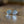 Load image into Gallery viewer, A pair of round silver-toned tie pins with an intricate Celtic knot design, resting on a wooden surface with a soft reflection.

