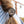 Load image into Gallery viewer, A close-up lifestyle shot of a person's brown hair tied back in a low braid with a round, antique bronze Celtic triquetra knot hair accessory.
