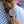 Load image into Gallery viewer, A close-up of a person's brown braided hair secured with a round silver-toned metal hair pin featuring an ornate Celtic knot design, wearing a blue and white patterned top.
