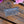 Load image into Gallery viewer, An ornate silver metal hair comb with intricate Celtic knotwork engraving on the rectangular head, displayed on a rustic wooden surface with pink flowers in the background.
