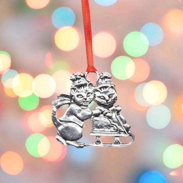 Traditional christmas decoration of two cats and a snow sleigh. Made from silver coloured Pewter.