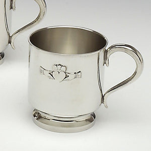 A BABY CUP WITH CLADDAGH DESIGN, USED TO CHRISTEN THE NEWBORN AND IDEAL AS A ROBUST CUP. PERFECT FOR ENGRAVING AS A PERSONALISED CUP IN MEMORY OF ANY OCCASION. PEWTER METAL SILVER FINISH MADE IN IRELAND