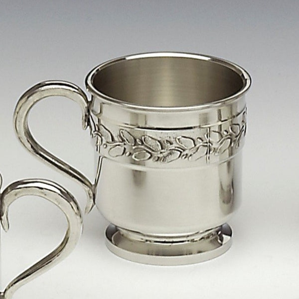 BABY CUP USED TO CHRISTEN A NEWBORN. ROBUST AND EASY TO PERSONALISE WITH NAMES AND DATES. MAKES A GREAT GIFT IN EVERY WAY. PEWTER BABY CUP WITH LEAF DESIGN PATTERN THAT RUNS AROUND THE BODY OF THE PEWTER METAL CUP.PEWTER METAL SILVER FINISH MADE IN IRELAND