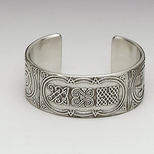 BANGLE BRACLET CELTIC. THIS MAKES A LOVELY GIFT FOR ANY WOMAN. THE CELTIC DESIGN IS TAKEN FROM THE BEALIN CROSS WHICH ONCE STOOD IN CLONMACNOISE. THE DESIGN IS THAT OF A HUNTING SCENE, CELTIC KNOT WORK AND ENTANGLED SWANS. THE BANGLE COMES BOXED IN A GREEN BANGLR BOX. PEWTER SILVER METAL