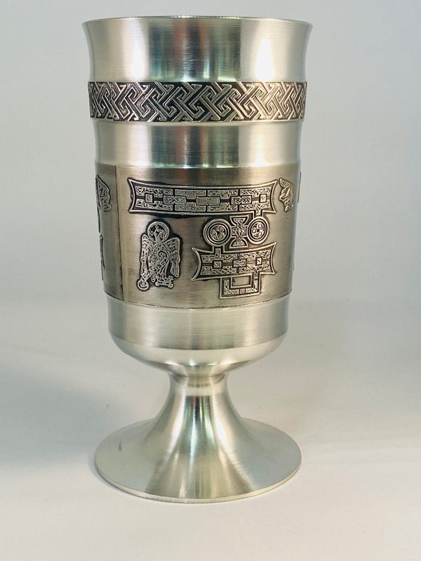A HANDCAST PEWTER GOBLET WITH THE LETTERS IP ETCHED ON THE OUTSIDE OF THE GOBLET ON THREE SIDES WITH AN EAGLE TYPE FIGURE ALL IN CELTIC FINISH WITH A CELTIC BAND ABOVE.  THE BASE IS FINISHED WITH A SOFT SILVER LOOK AND THE INSIDE OF THE GOBLET IS HAND TURNED. ÉTAIN ZINN HARTZINN PELTRO METAL