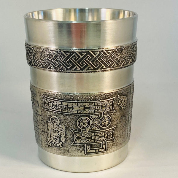 BOOK OF KELLS 10 FLUID OZ DRINKS BEAKER WITH THE CELTIC LETTERS IP AROUND THE OUTSIDE OF THE BEAKER. PEWTER SILVER FINISHED RIMS WITH CELTIC LETTERS FINISHED IN SOFT SHEEN FINISH. BEAKER IS 4" TALL.