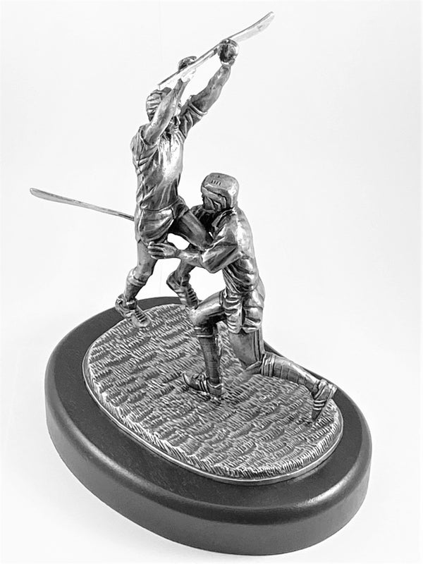 ACTION SCULPTURE OF TWO HURLERS COMPETING FOR THE BALL. MADE OF PEWTER METAL WITH SILVER FINISH POLISH. IRELAND. 