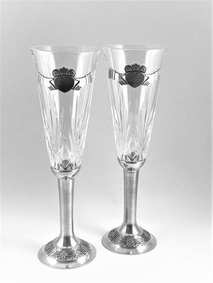 CLADDAGH CRYSTAL WEDDING FLUTES SET OF TWO. EACH GLASS IS 8 1/2"TALL AND HAS A PEWTER STEM WITH CELTIC DESIGN AND A CLADDAGH, THE IRISH LOVE SYMBOL ATTACHED TO THE CRYSTAL GLASS. PEWTER CRYSTAL HANDMADE IN IRELAND