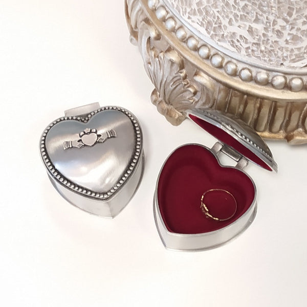 Two heart shaped Jewellery boxes one closed with a claddagh motif the second with red inlay. 