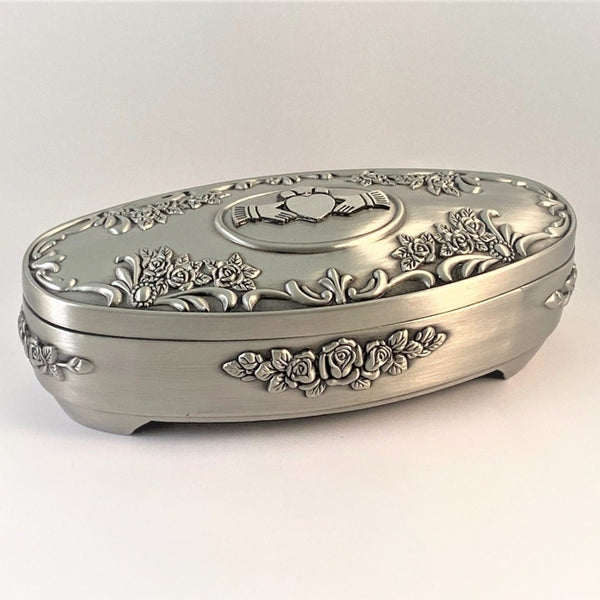JEWELLERY BOX OVAL CLADDAGH. THIS 6 1/2" LONG BOX IS IDEAL TO HOLD THOSE PRECIOUS PIECES OF JEWELRY. IT IS SURROUNDED WITH ROSE DESIGN AND CLADDAGH ON THE LID."