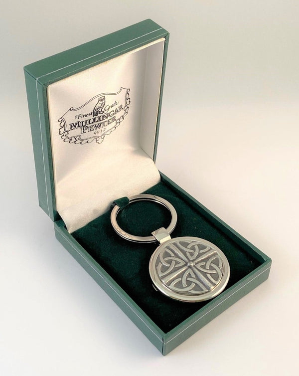 KEY CHAIN TRINITY DESIGN BOXED IN A GREEN PRESENTATION BOX. THIS LITTLE SOMETHING MAKES A GREAT GIFT. THENDESIGN IS THAT OF 4 TRINITIES FORMED INTO A CIRCLE WITH A CROSS IN THE CENTRE. MADE OF PEWTER WITH A SOFT SILVER FINISH. PEWTER SILVER METAL