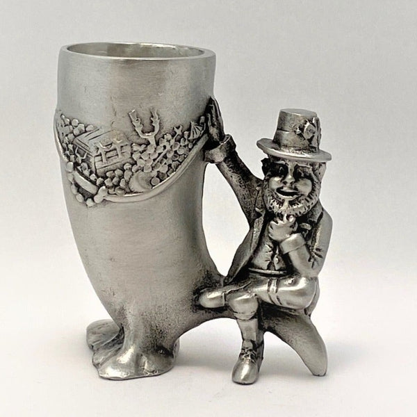 LEPRECHAUN SHOT MEASURE. A GREAT MANS GIFT. THE RELAXED LEPRECHAUN SITS SMOKING HIS PIPE GUARDING HIS COLLECTION OF RICHES. A GREAT SHOT GLASS FOR THE FUN LOVING WHISKEY LOVER.  PEWTER /SILVER  METAL