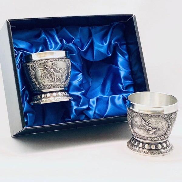 WOODLANDS WHISKEY TUMBLERS SET OF 2. These tumblers stand at almost 3" tall and hold 8 fluid ozs. The decoration is of wildlife animal scenes in a woodlands setting. The set of two are just perfect for toasting any occasion. Each set is boxed in a blue satin lined presentation box. Handmade in Ireland by Mullingar Pewter