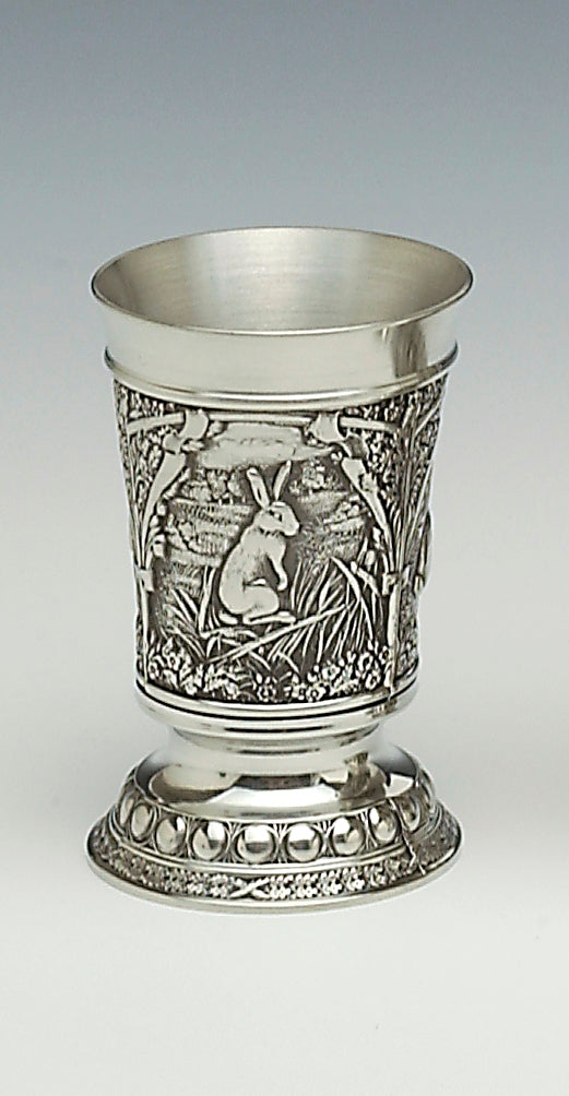 WOODLANDS BEAKER WITH WILD HARE SCENES IN LONG GRASS. THE BEAKER IS 5 1/2" HIGH AND HOLDS 12 FLUID OZS OF YOUR FAVOURATE BEVERAGE. pEWTER WITYH SILVER FINISHED TOP AND LOWER RIMS.