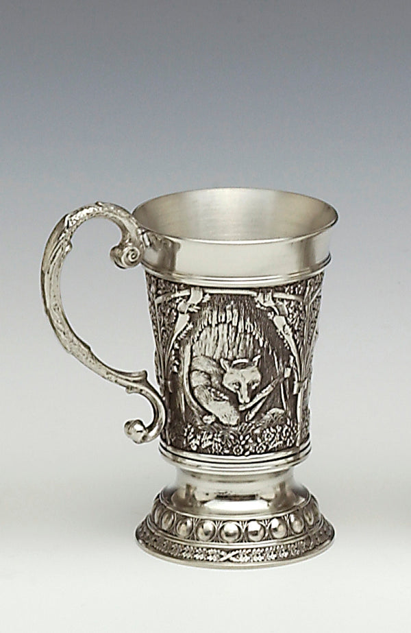 THIS PEWTER MEASURE WITH DECORATDE HANDLE STANDS 2" TALL AND HOLDS 1 FLUID OZ. THE MEASURE IS SURROUNDED WITH FOX WILDLIFE SCENES FROM THE WOODLADS OF IRELAND. THE BASE IS DECORATED WITH BEADING. HANDMADE IN IRELAND BY MULLINGAR PEWTER.
