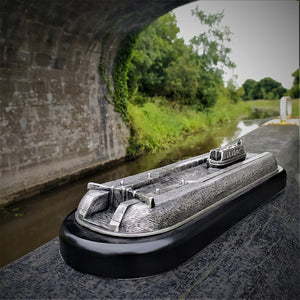 Canal sculture made from Mullingar Pewter, a silver metal. Depicting a barge alonf the canal approaching a lock gate. This shot was taken under the bridge on the Royal canal at The Downs, Mullingar Ireland.