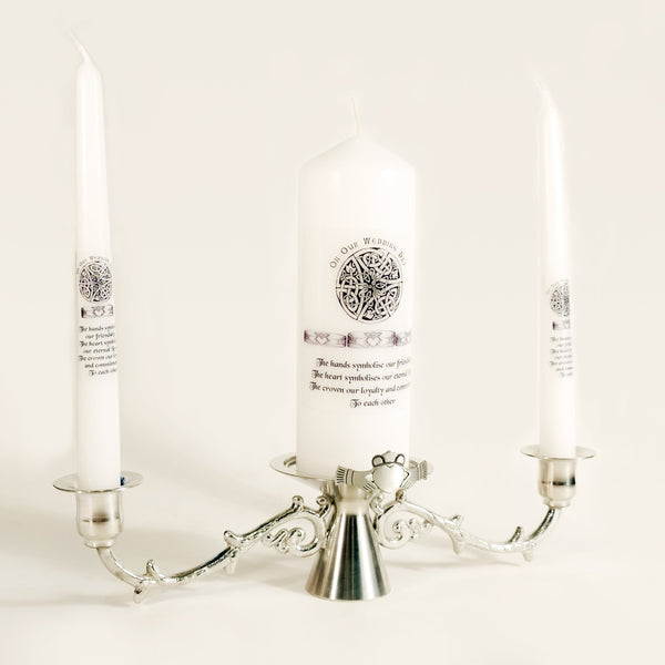 Mullingar Pewter Candle stick holder handcrafted in silver colour pewter with a claddagh motif. A set of white wedding candles sitting on top with claddagh and celtic motif. 